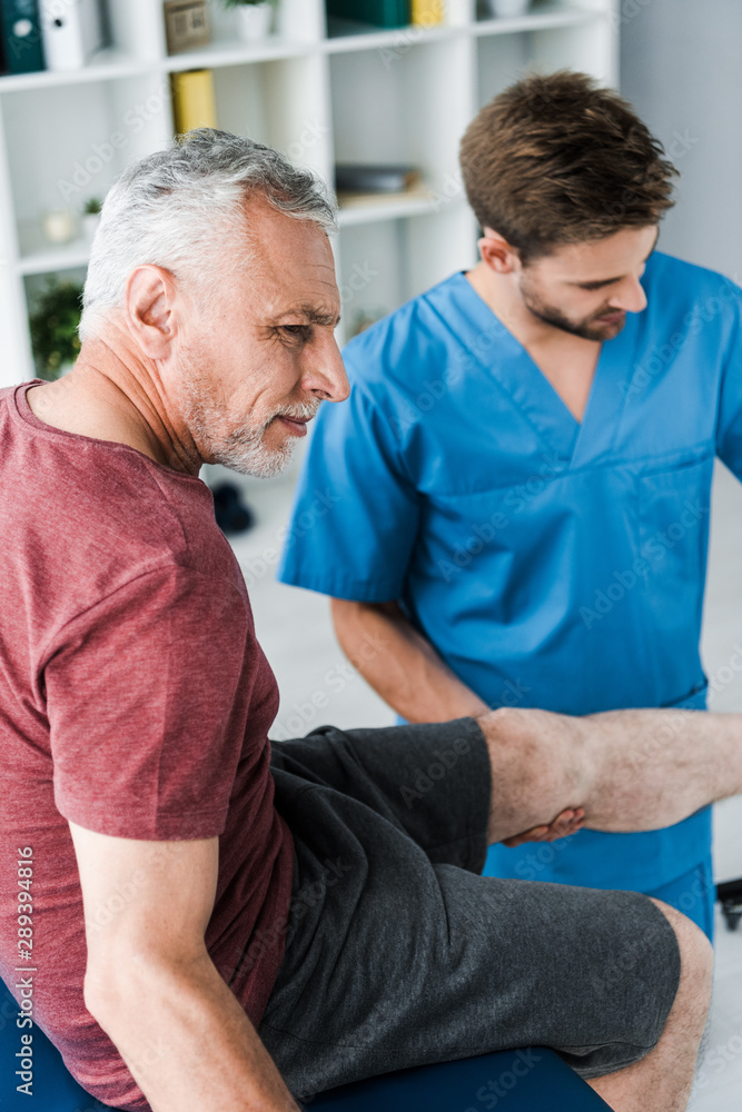 selective focus of bearded patient with pain near doctor selective focus of bearded patient with pain near doctor