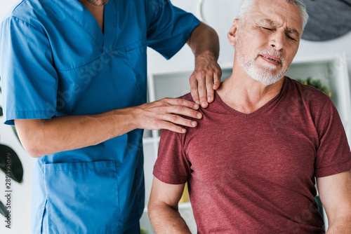 cropped view of doctor near bearded man with closed eyes