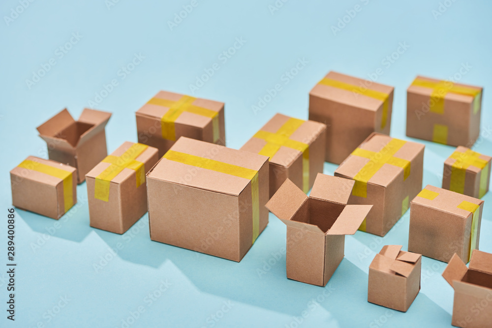 postal cardboard boxes on blue background with copy space