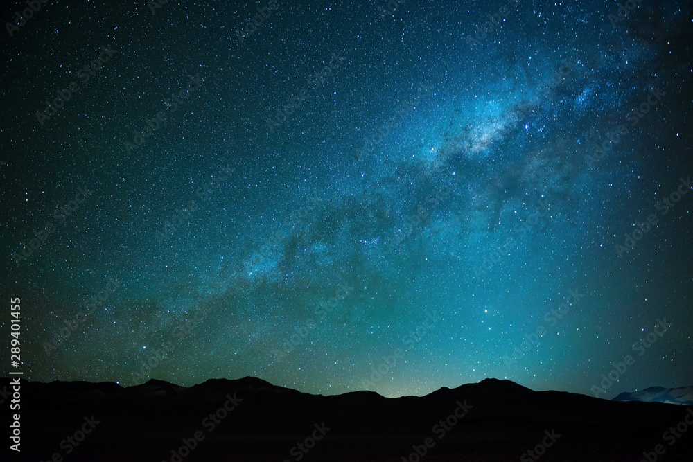 Naklejka The milky way shining in the Siloli desert at high altitude in the Andes mountain range of Bolivia near Atacama, South America.