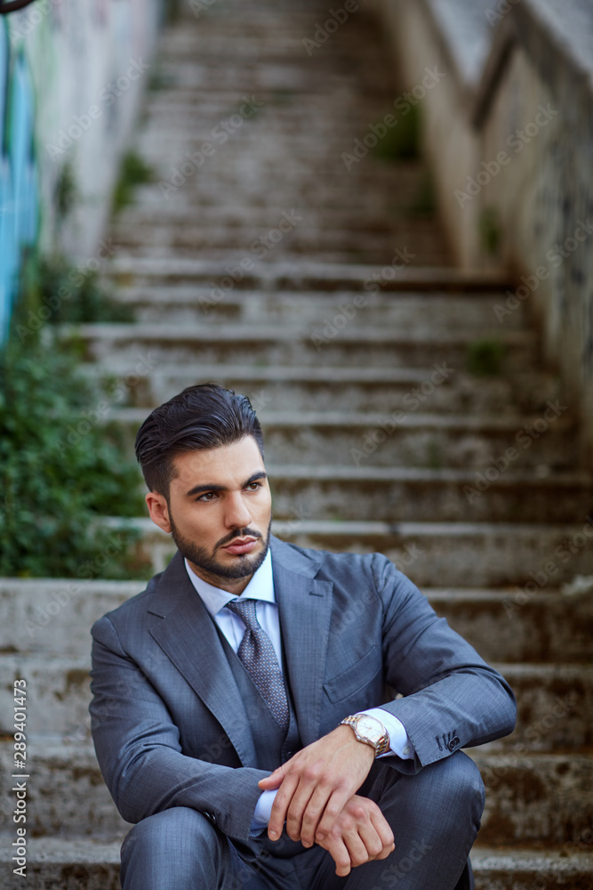 Fashion businessman sit down on old stairway Fashion businessman sit down on old stairway