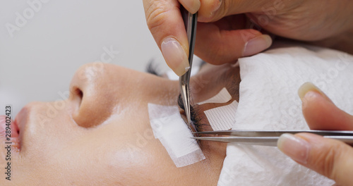 Woman having eyelash extension in beauty salon