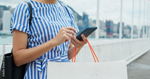Photography Woman use of mobile phone with shopping bag