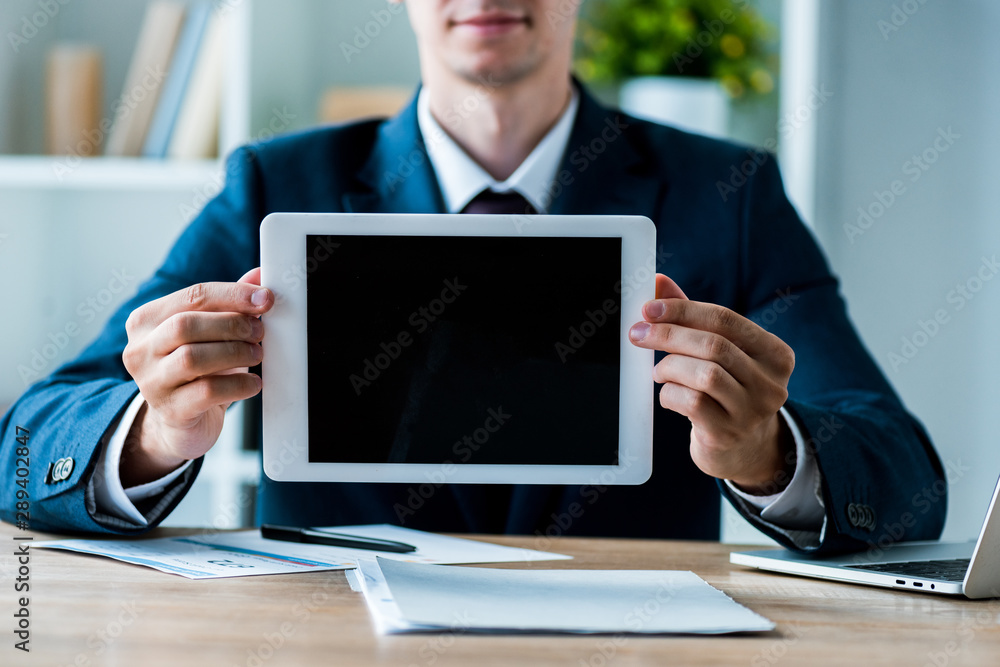 selective focus of happy man holding digital tablet with blank screen in office selective focus of happy man holding digital tablet with blank screen in office