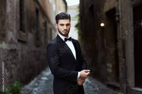 Businessman with james bond dress in little street in Rome