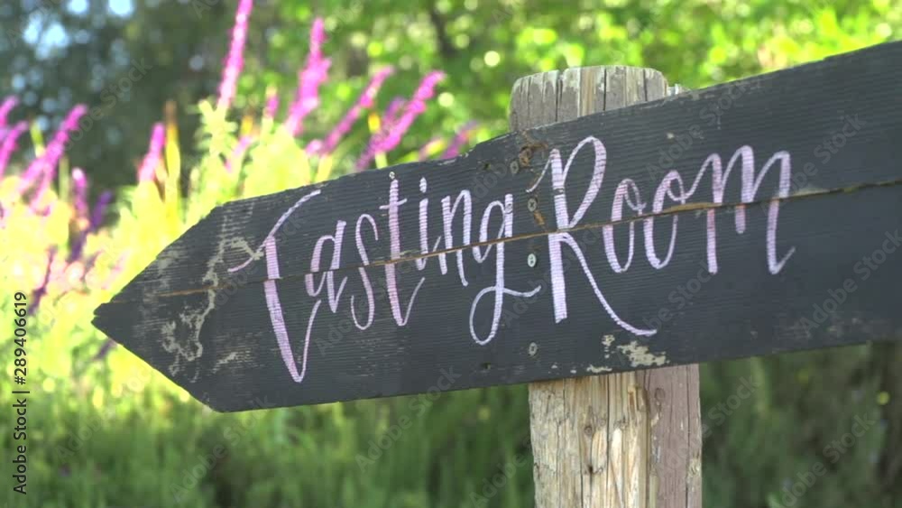 pan to rustic wood wine tasting room sign outside on a sunny day pan to rustic wood wine tasting room sign outside on a sunny day