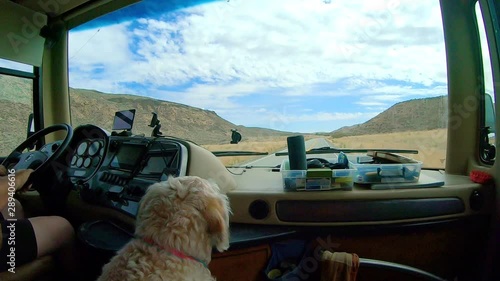 POV of the passenger in a large class A Recreational Vehicle while driving through the Okanogan Highlands of north central Washington State with a labradoodle dog in the foreground photo