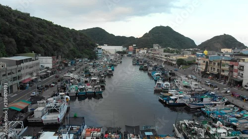 AERIAL: Drone Rises Over Fishing Harbor Full of Fishing Boats with Tilt Down - Suao, Taiwan photo