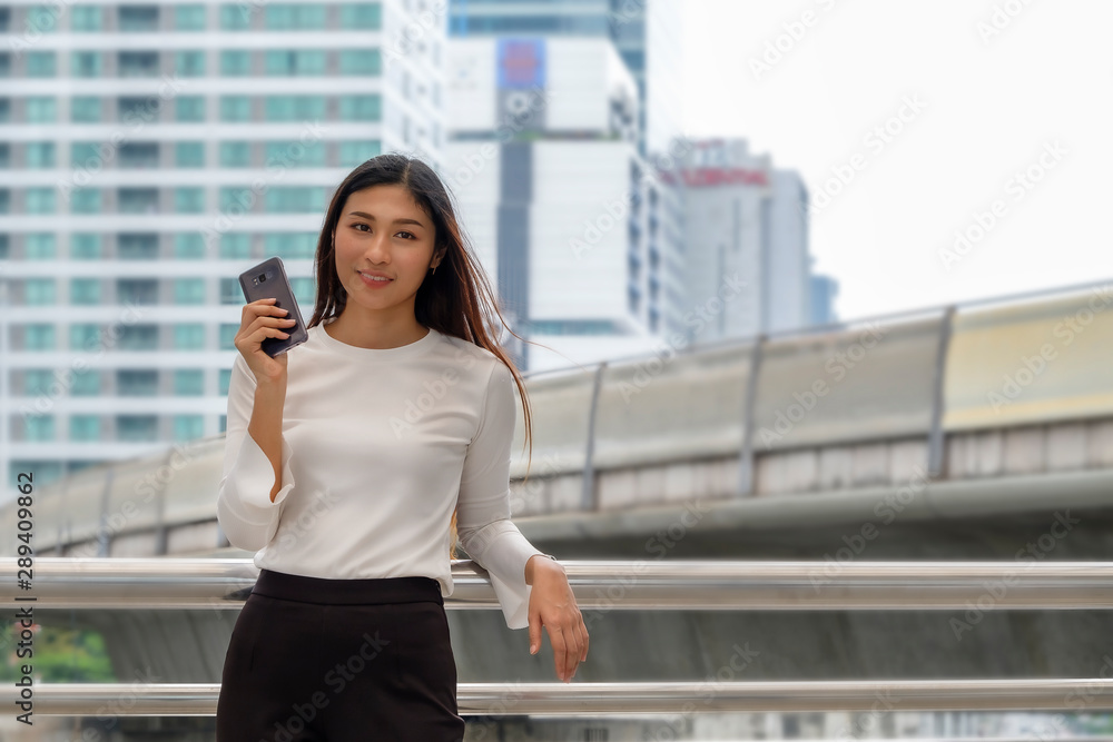 business woman is using and talking on mobile phone in city business woman is using and talking on mobile phone in city