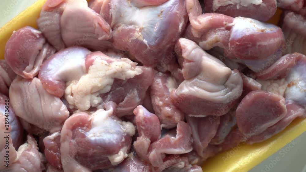 Fresh raw сhicken offal in food tray rotating in microwave top view. Fresh raw сhicken offal in food tray rotating in microwave top view.