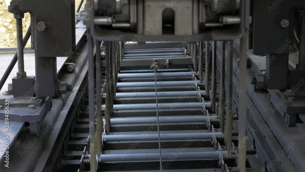 Fully mechanised process of concrete road construction. The slipform paver inserts dowel bars in the fresh concrete. Fully mechanised process of concrete road construction. The slipform paver inserts dowel bars in the fresh concrete.