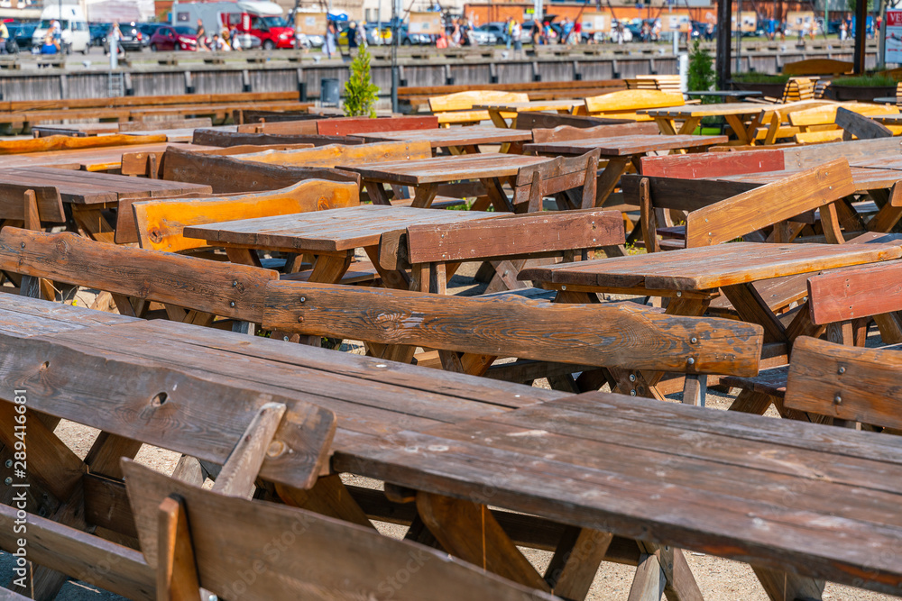 Many wooden tables and benches. The summer season is over. No visitors to the beer bar. Many wooden tables and benches. The summer season is over. No visitors to the beer bar.