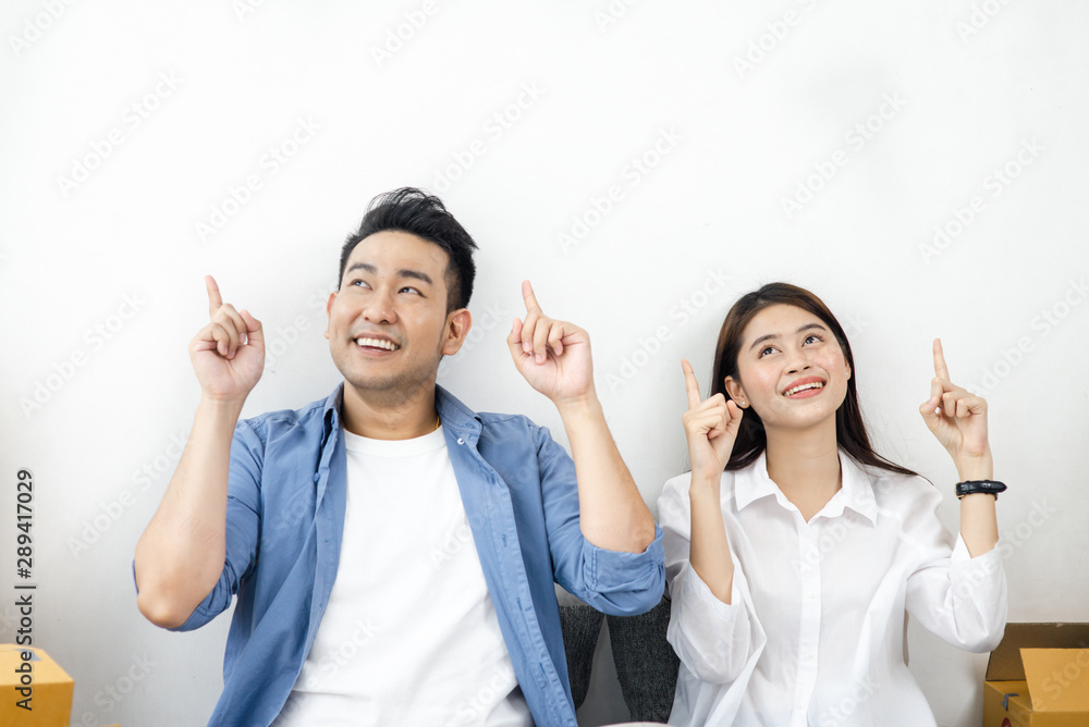 Asian couple poiting with stack of parcel boxes, online business and delivery concept. Asian couple poiting with stack of parcel boxes, online business and delivery concept.