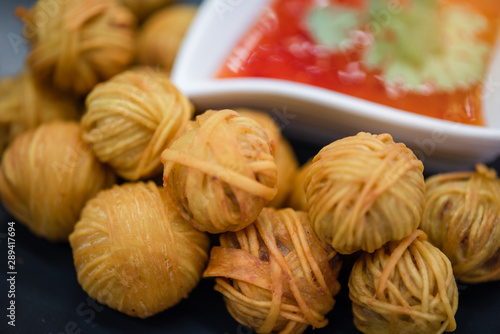 "Moo Sarong" is Thai traditional snack made with minced pork, mixed with coriander root, pepper, fish sauce, garlic ,Chinese yellow noodle fried to eaten with dipping sauce.