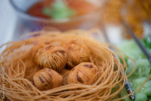 "Moo Sarong" is Thai traditional snack made with minced pork, mixed with coriander root, pepper, fish sauce, garlic ,Chinese yellow noodle fried to eaten with dipping sauce.