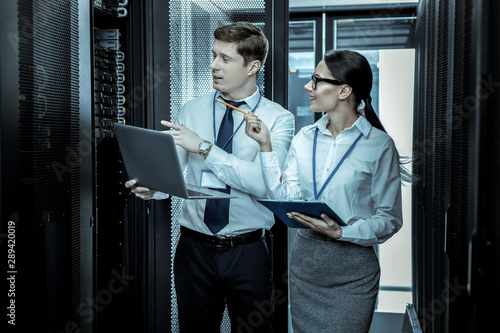 Two security guards in eyeglasses working together with the laptops photo