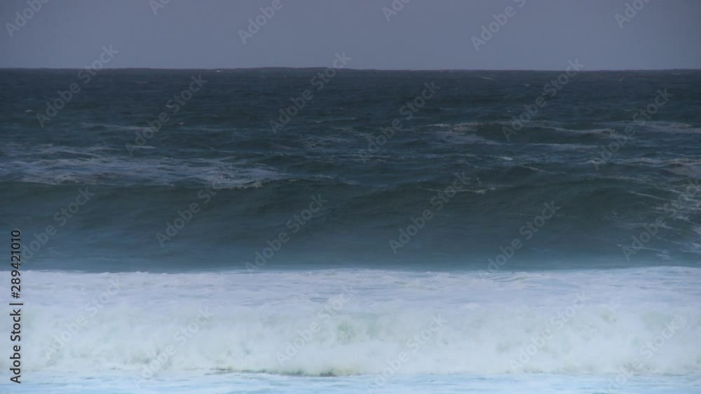 Handheld, panning, medium close up shot of medium sized waves crashing in the sea. Handheld, panning, medium close up shot of medium sized waves crashing in the sea.