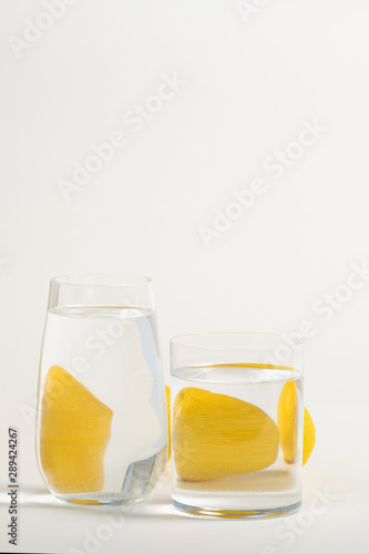 Foods distorted through liquid and glass on white background.