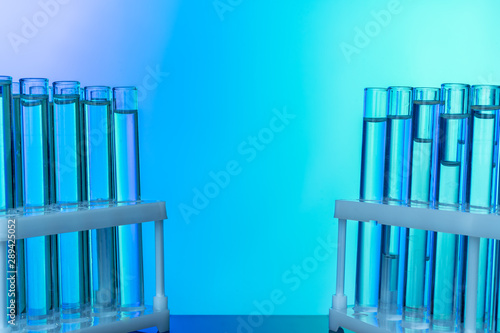 Row of test tubes with liquids on blue and green toned background