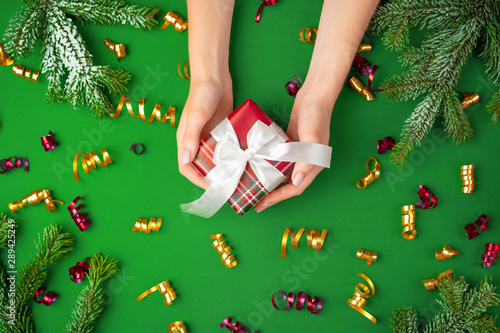 Hands holding christmas present on a green background