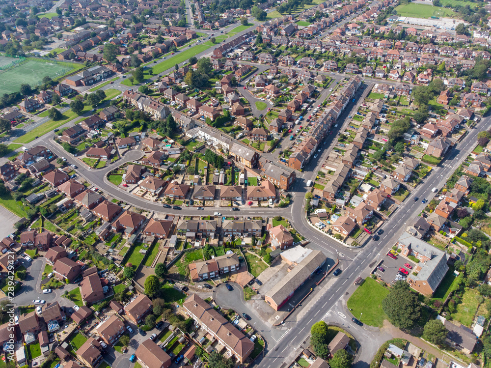 Naklejka premium Aerial photo of the British town of Middleton in Leeds West Yorkshire showing typical suburban housing estates with rows of houses, taken on a bright sunny day using a drone.
