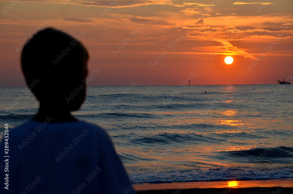 Fototapeta premium Alba sul mare con bambino