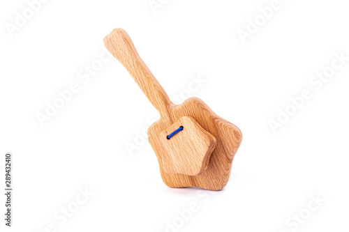Photo of wooden rattle in the shape of a star on a white isolated background for a baby.A toy for entertaining children and resting parents