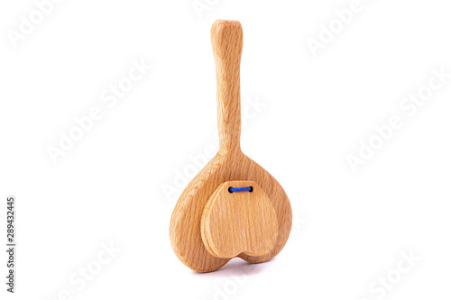 Photo of wooden rattles in the shape of a heart on a white isolated background for a baby.A toy for entertaining children and resting parents