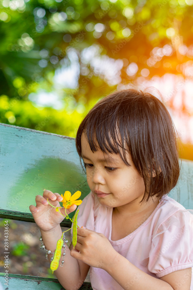 Asian children girl with flowers in the park. Asian children girl with flowers in the park.