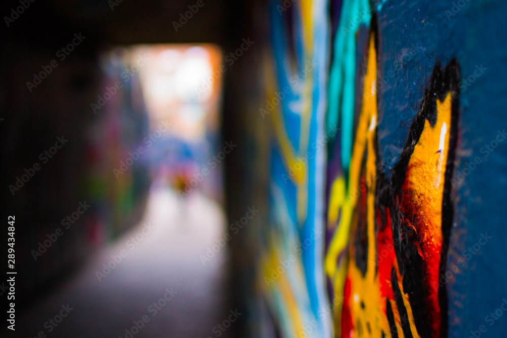 Close up of a red and orange graffity in Werregarenstraat (Graffiti Street) in Ghent, Belgium, Europe, with defocused background. Colorful famous street in the old town of Ghent