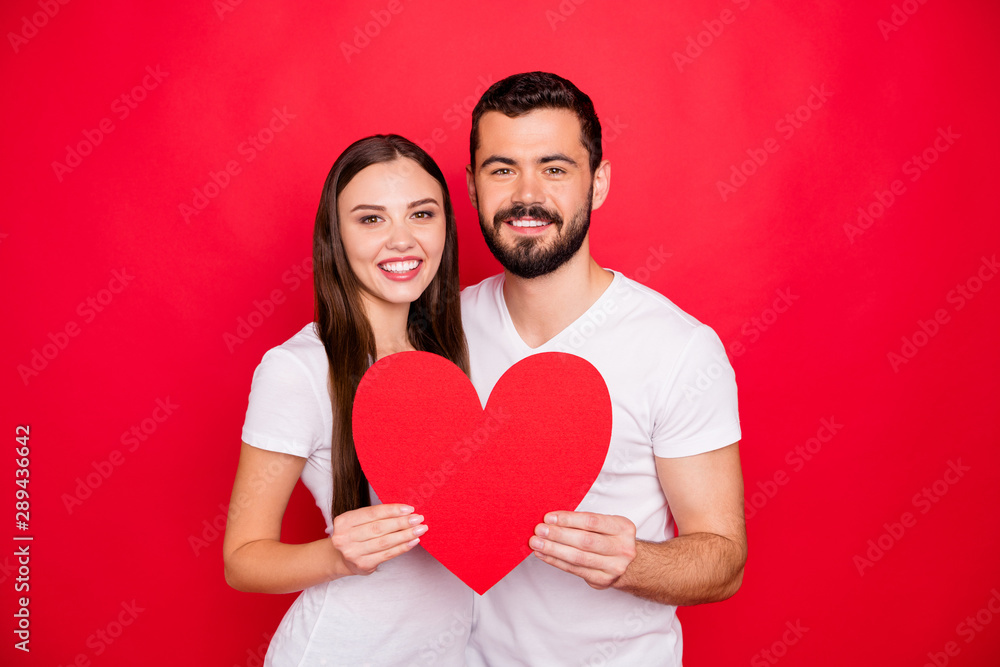 Photo of couple of two casual stylish charming trendy fascinating people couple together showing you big heart symbolizing their love while isolated with red background