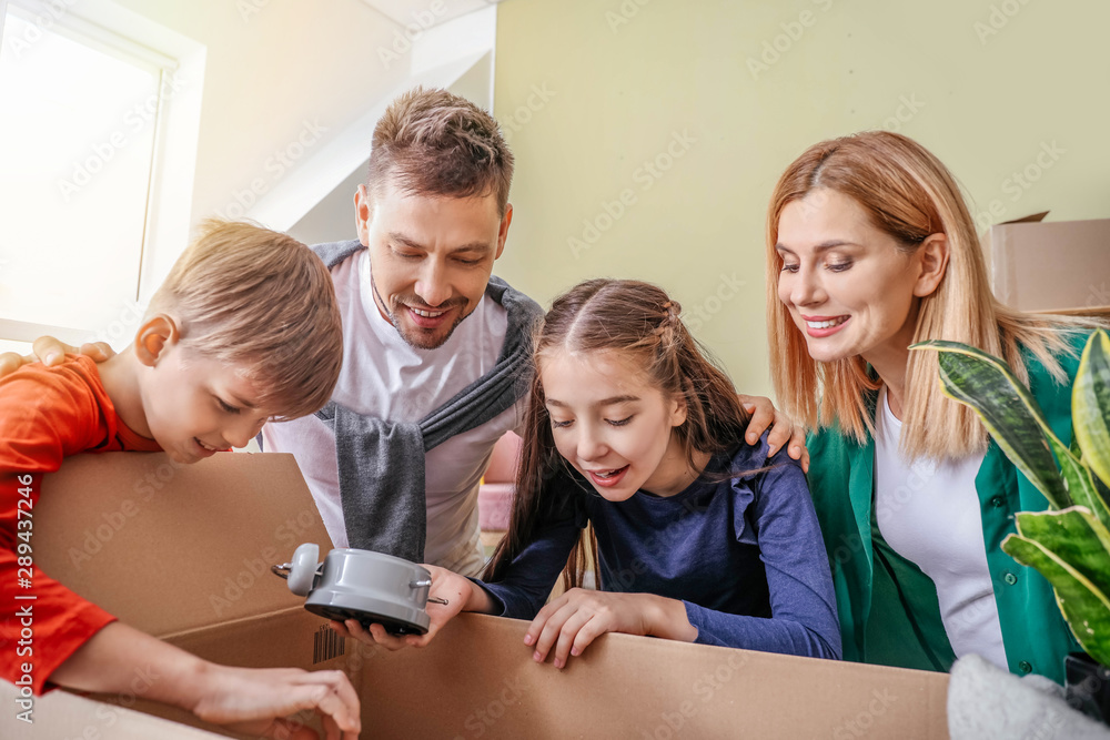 Happy family unpacking belongings in their new house Happy family unpacking belongings in their new house