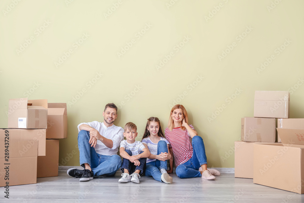 Happy family with belongings in their new house Happy family with belongings in their new house