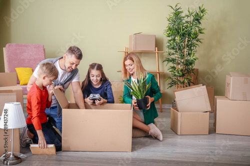 Happy family unpacking belo...