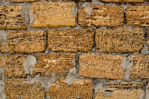 Brick wall of yellow shell rock. Closeup of shellstone texture. Background wall with shell rock. Old wall. Texture limestone photo