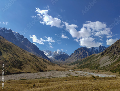 Trans-Ili Alatau mountain range of the Tien Shan system in Kazakhstan near the city of Almaty. Rocky peaks covered with snow and glaciers in the middle of summer under clouds