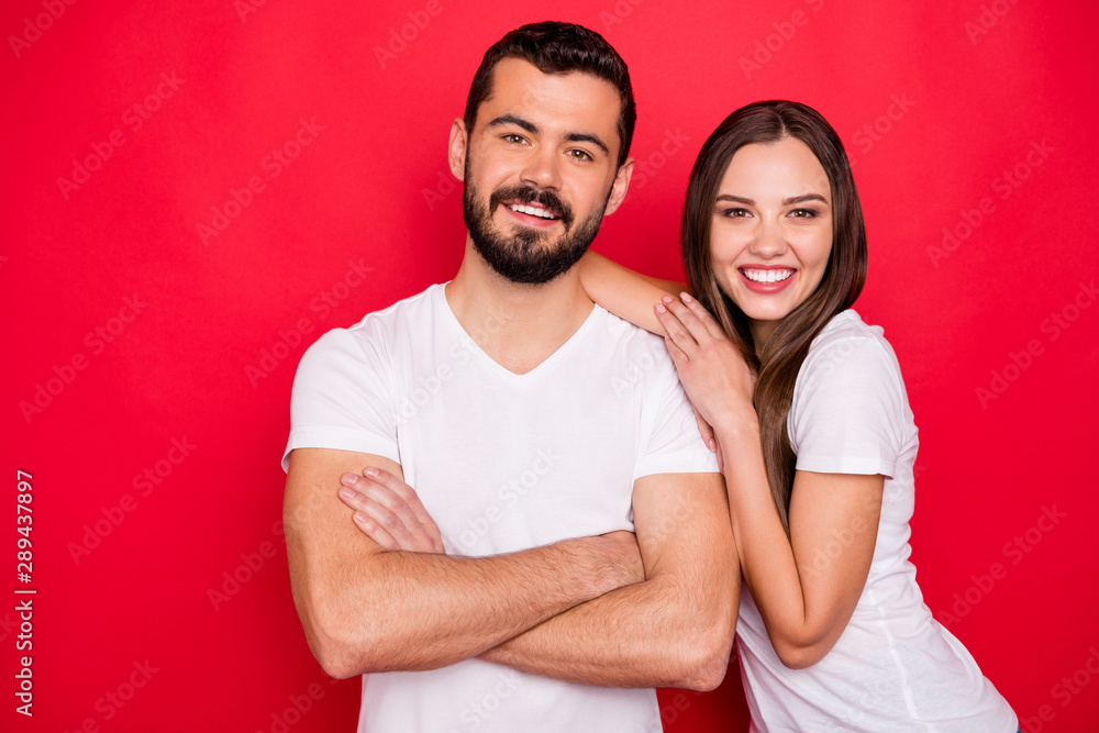 Photo of cute nice handsome beautiful couple of spouses friendly and kindly looking at you while isolated with red background Photo of cute nice handsome beautiful couple of spouses friendly and kindly looking at you while isolated with red background