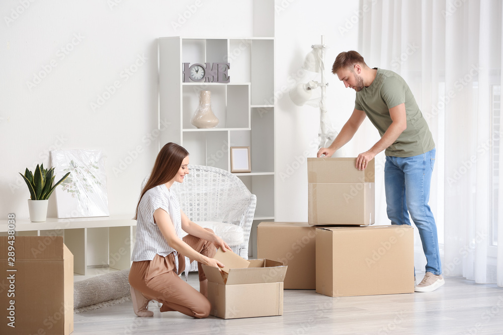 Young couple unpacking things after moving into new house Young couple unpacking things after moving into new house