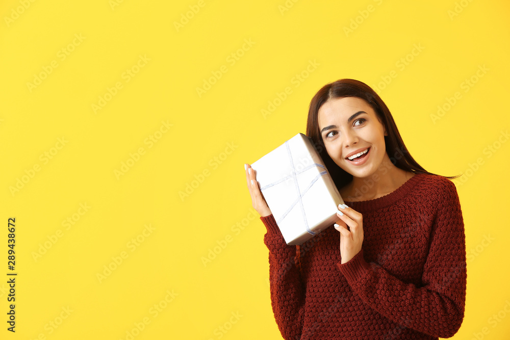 Beautiful young woman with gift on color background Beautiful young woman with gift on color background