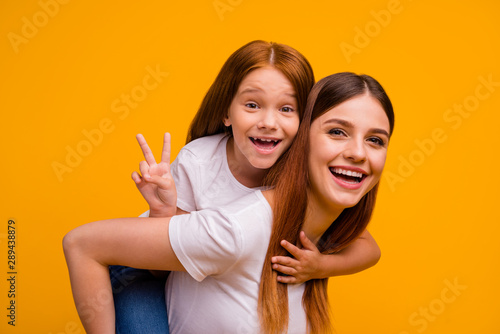 Close-up portrait of two nice-looking attractive lovely cheerful cheery glad playful person having fun free time holiday weekend showing v-sign isolated over bright vivid shine yellow background