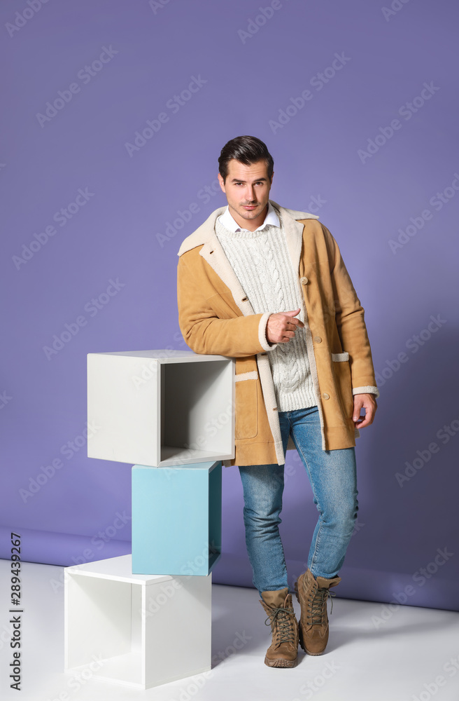 Fashionable man in warm clothes on color background Fashionable man in warm clothes on color background