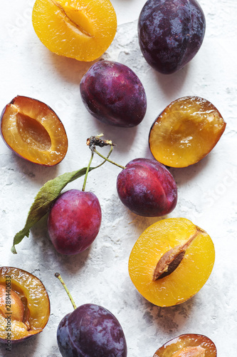 Many fresh plums on light grey background isolated