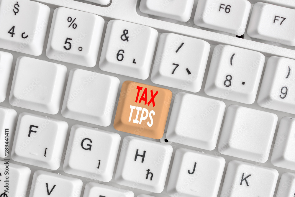 Writing note showing Tax Tips. Business concept for compulsory contribution to state revenue levied by government White pc keyboard with note paper above the white background Writing note showing Tax Tips. Business concept for compulsory contribution to state revenue levied by government White pc keyboard with note paper above the white background