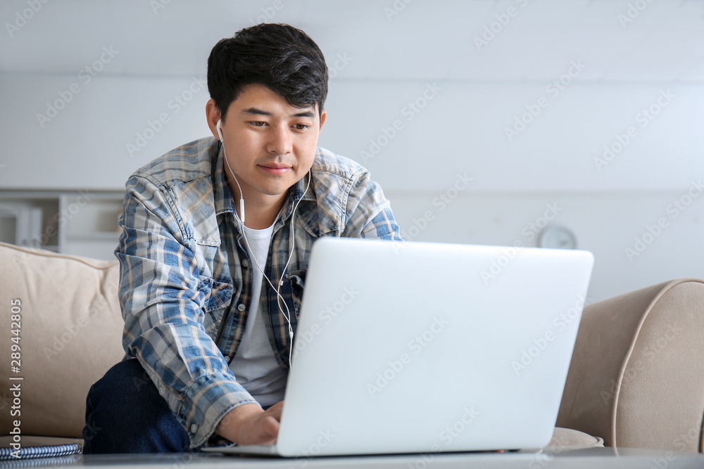 Asian student with laptop preparing for exam at home Asian student with laptop preparing for exam at home