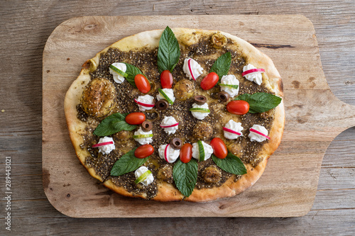 lebanese Manoushe ,bread of thyme topped with mint, reddish, and Labneh; Lebanese Zaatar Manouche; zaatar flat bread photo