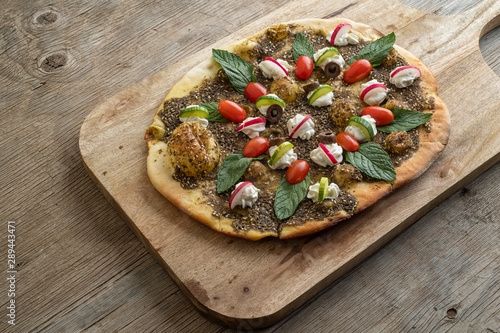 lebanese Manoushe ,bread of thyme topped with mint, reddish, and Labneh; Lebanese Zaatar Manouche; zaatar flat bread photo