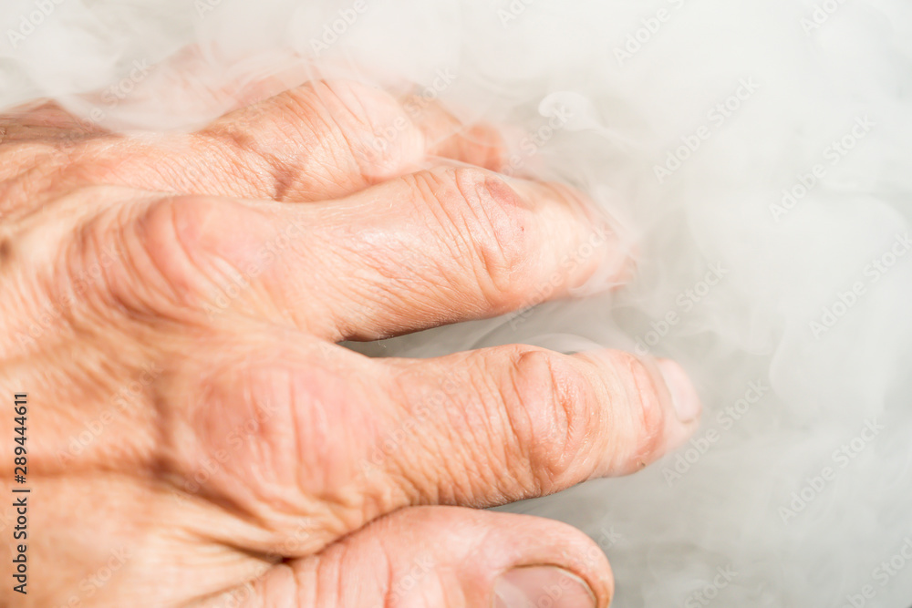 Hand of a man in the white smoke from the fire Hand of a man in the white smoke from the fire