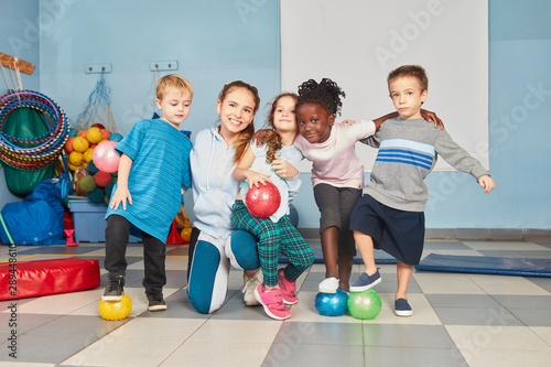 Lehrerin und Kinder Gruppe mit Bällen