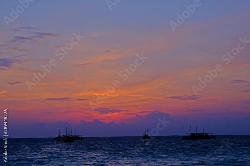 Beautiful sunset sky with silhouette fisherman boats