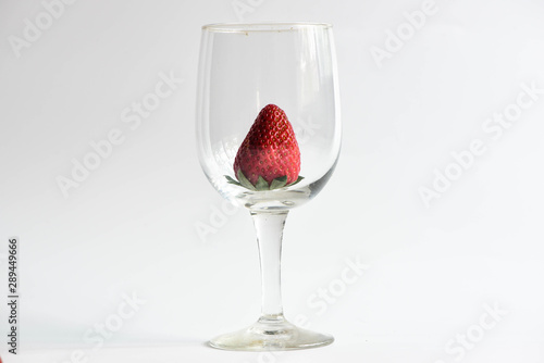 Strawberry in wine glass on white background
